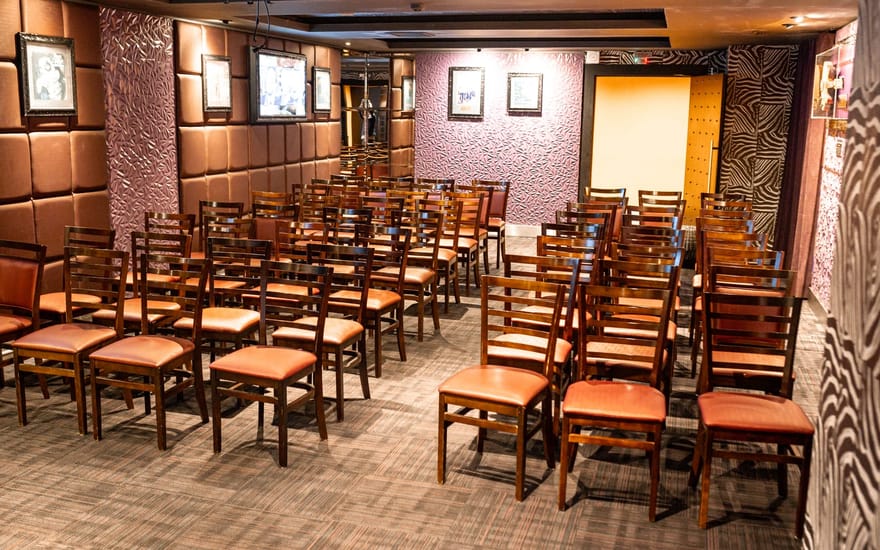 Sala do Hard Rock Cafe Curitiba montada em formato auditório, com fileiras de cadeiras voltadas para a frente